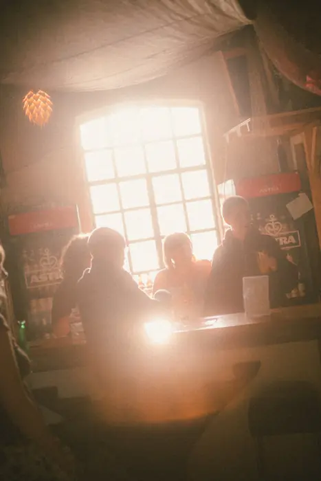 Menschen an der Bar vor dem hellen Fenster