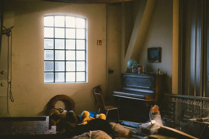 Sonnenlicht durch das Rundbogenfenster auf Klavier und Sofa