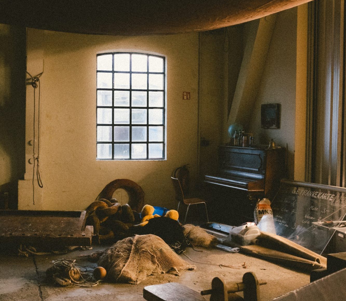 Der Raum im Heineschuppen: Rundbogenfenster, Klavier und Werkbank